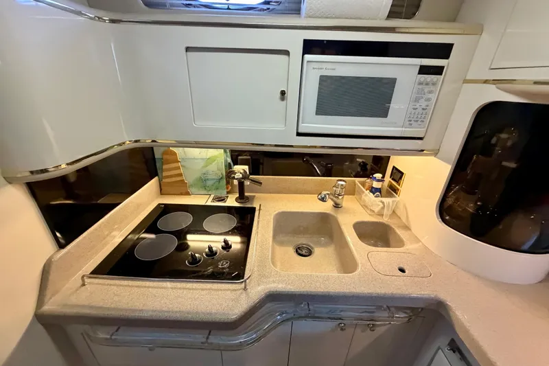 Slide: The Image of 1997 Sea Ray 500 Sundancer kitchen with stove, sink, and microwave. - 27