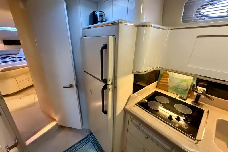 Slide: The Image of Interior of a 1997 Sea Ray 500 Sundancer yacht kitchen with stove and refrigerator. - 28