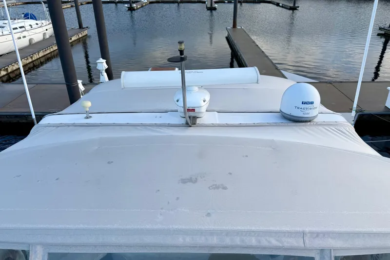 Slide: The Image of 1997 Sea Ray 500 Sundancer docked, featuring TracVision satellite equipment on the roof. - 4