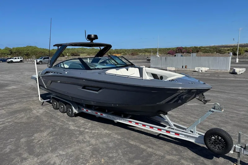 Slide: The Image of 2022 Cruisers Yachts 338 South Beach Edition Bow Rider on trailer, parked outdoors. - 12