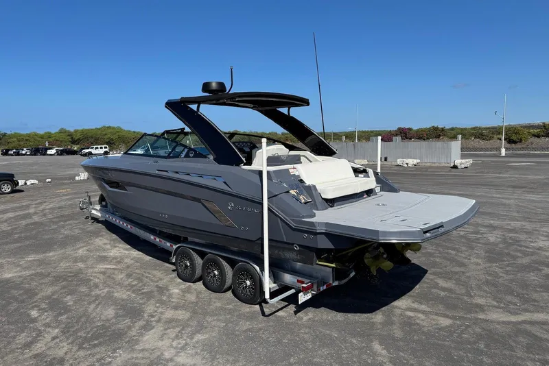 Slide: The Image of 2022 Cruisers Yachts 338 South Beach Edition Bow Rider on trailer, parked outdoors. - 16