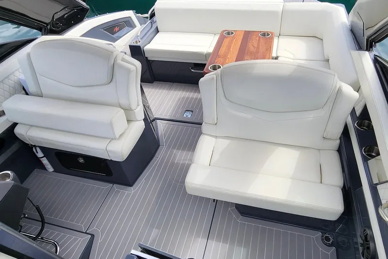 Slide: The Image of 2022 Cruisers Yachts 338 South Beach Edition Bow Rider interior with white seating and wooden table. - 21
