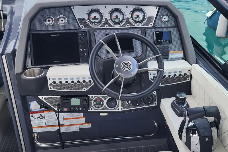 Slide: The Image of 2022 Cruisers Yachts 338 South Beach Edition Bow Rider dashboard with modern controls and steering. - 23