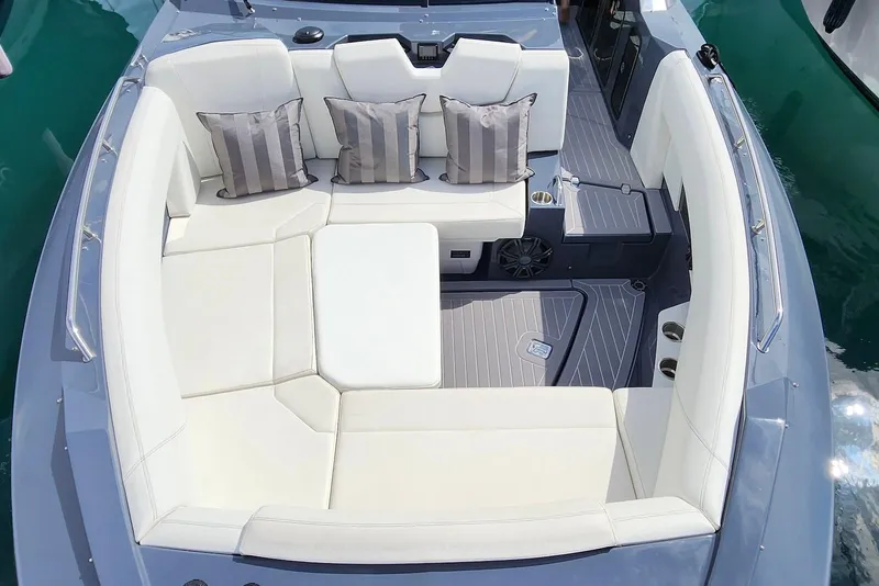 Slide: The Image of 2022 Cruisers Yachts 338 South Beach Edition Bow Rider with luxurious seating and striped cushions. - 24