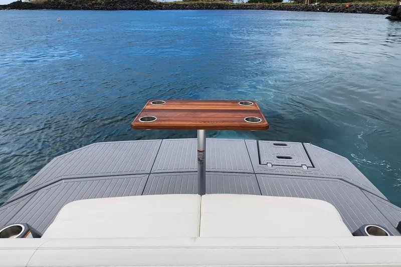 Slide: The Image of 2022 Cruisers Yachts 338 South Beach Edition Bow Rider on water, featuring a wooden table. - 28