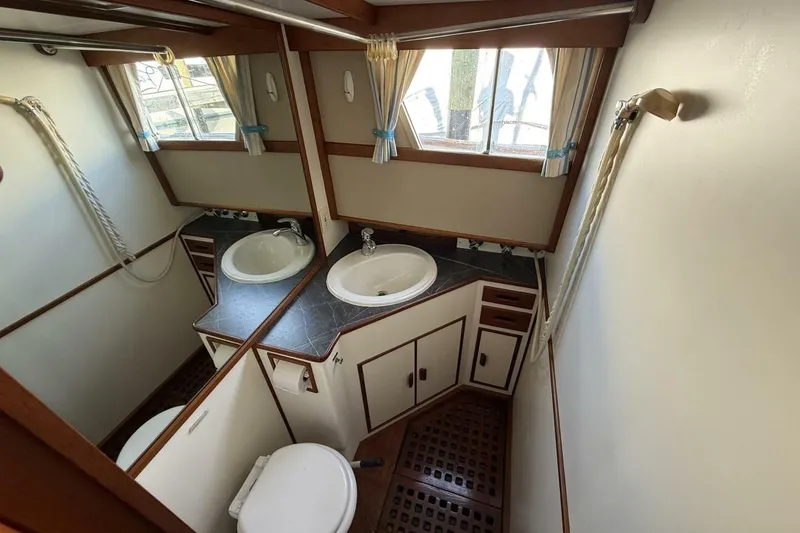 Slide: The Image of 1985 Grand Banks 36 Classic yacht bathroom with sink, toilet, and wooden accents. - 16