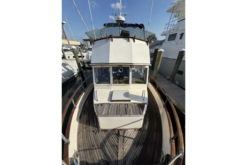 Slide: The Image of 1985 Grand Banks 36 Classic boat docked at marina, showcasing wooden deck and cabin. - 3