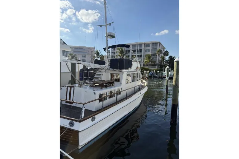 Slide: The Image of 1985 Grand Banks 36 Classic yacht docked in a marina, under a clear blue sky. - 4