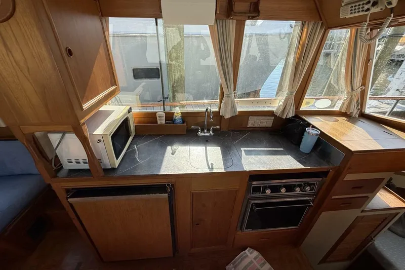 Slide: The Image of 1985 Grand Banks 36 Classic yacht kitchen with microwave, stove, and sink. - 8