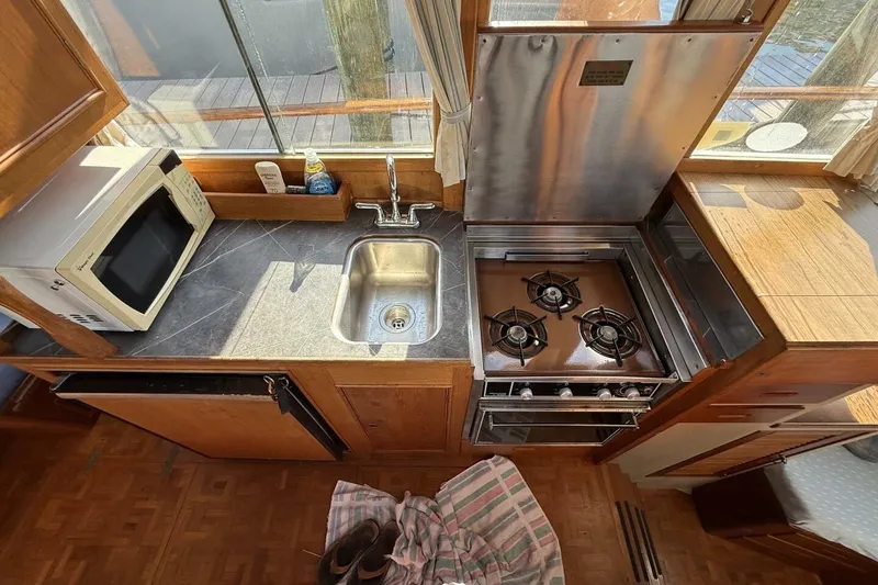 Slide: The Image of Galley kitchen in 1985 Grand Banks 36 Classic boat with stove, sink, and microwave. - 9