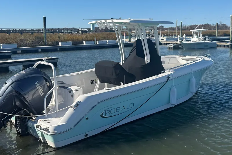 Slide: The Image of 2022 Robalo R242 Explorer boat docked with Yamaha outboard engine. - 10
