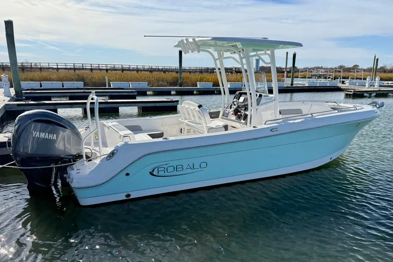 Slide: The Image of 2022 Robalo R242 Explorer boat docked with Yamaha engine, clear sky background. - 11