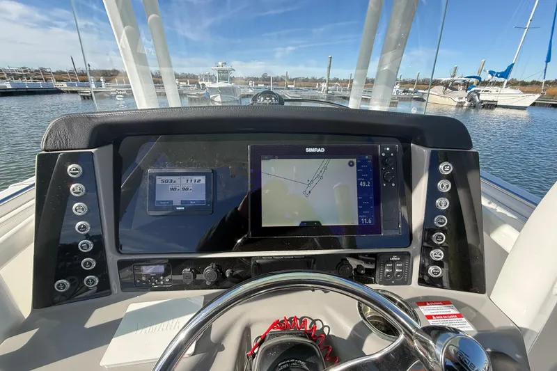 Slide: The Image of 2022 Robalo R242 Explorer dashboard with navigation system and controls at marina. - 14