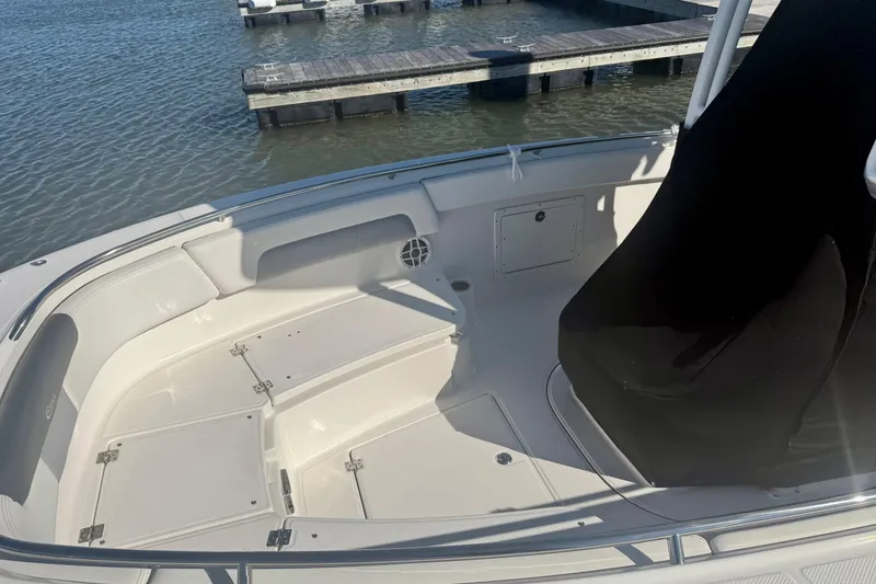 Slide: The Image of 2022 Robalo R242 Explorer boat interior with seating and storage, docked by the water. - 17