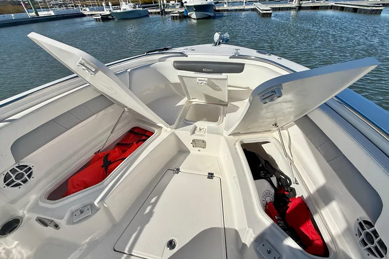 Slide: The Image of 2022 Robalo R242 Explorer boat with open storage compartments at a marina. - 21