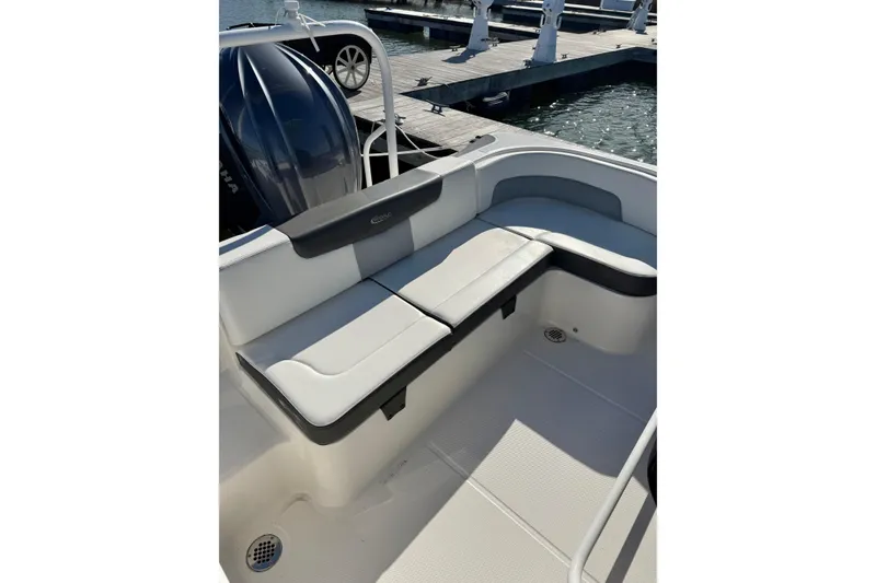 Slide: The Image of 2022 Robalo R242 Explorer boat interior with cushioned seating at the dock. - 5