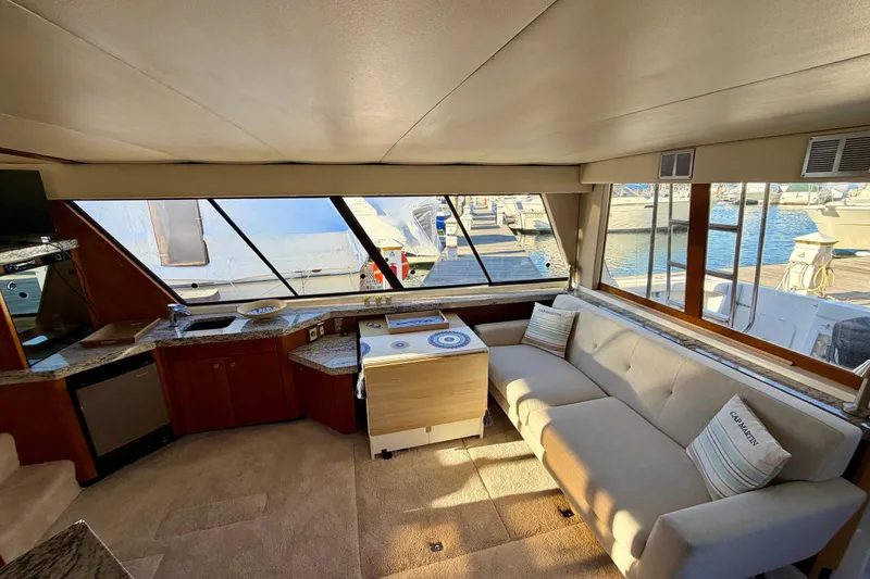 Slide: The Image of Interior of 1995 Bayliner 4788 Pilot House Motoryacht with spacious seating and large windows. - 10