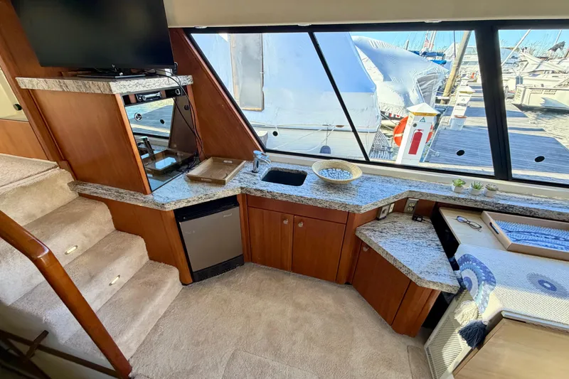 Slide: The Image of Luxurious 1995 Bayliner 4788 Pilot House Motoryacht interior with modern kitchen and scenic marina view. - 14