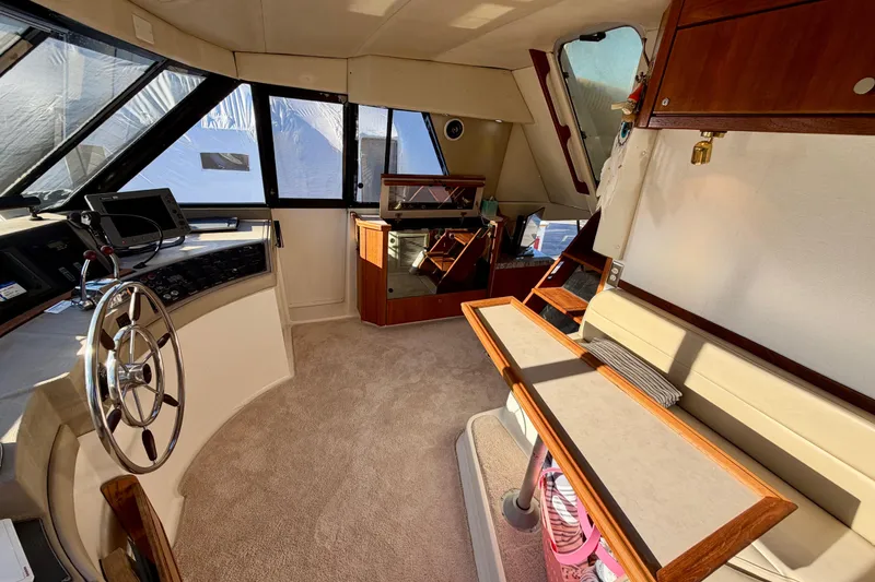 Slide: The Image of Interior of 1995 Bayliner 4788 Pilot House Motoryacht with helm and seating area. - 23