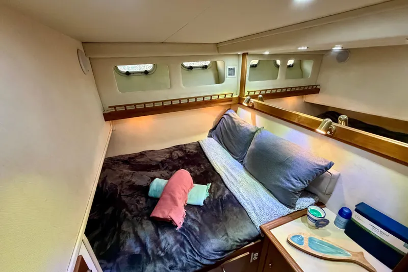 Slide: The Image of Cozy bedroom in 1995 Bayliner 4788 Pilot House Motoryacht with plush bedding and ambient lighting. - 30