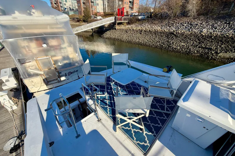 Slide: The Image of 1995 Bayliner 4788 Pilot House Motoryacht with outdoor seating on deck, docked by waterfront. - 46