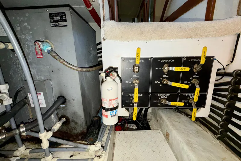 Slide: The Image of Engine room of 1995 Bayliner 4788 Pilot House Motoryacht with control panel and fire extinguisher. - 52