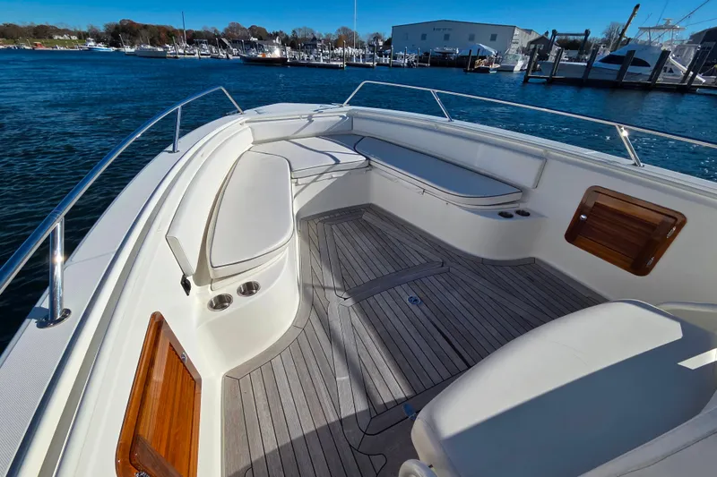 Slide: The Image of 2013 Boston Whaler 320 Outrage boat interior with seating and wooden deck. - 10