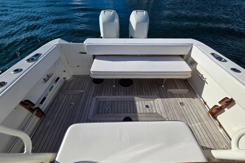 Slide: The Image of 2013 Boston Whaler 320 Outrage boat interior with seating and twin engines on water. - 13