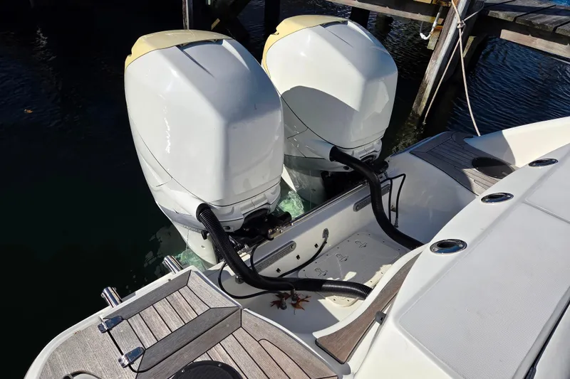 Slide: The Image of Twin outboard engines on a 2013 Boston Whaler 320 Outrage boat docked by the water. - 8