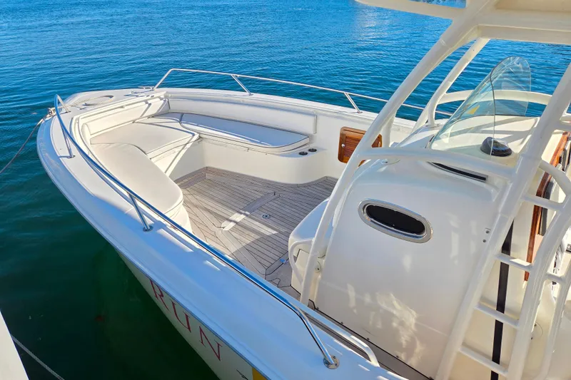Slide: The Image of 2013 Boston Whaler 320 Outrage boat with spacious deck and seating on calm water. - 9