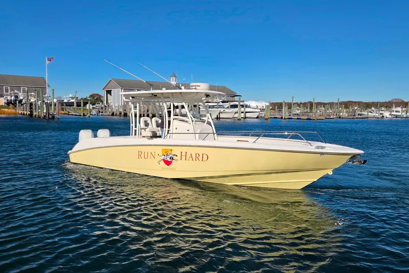 The Image of 2013 Boston Whaler 320 Outrage boat on water, sunny day, marina background. - 0