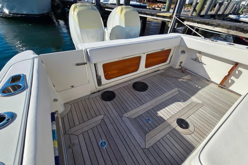 Slide: The Image of 2013 Boston Whaler 320 Outrage boat deck with wooden flooring and storage compartments. - 12
