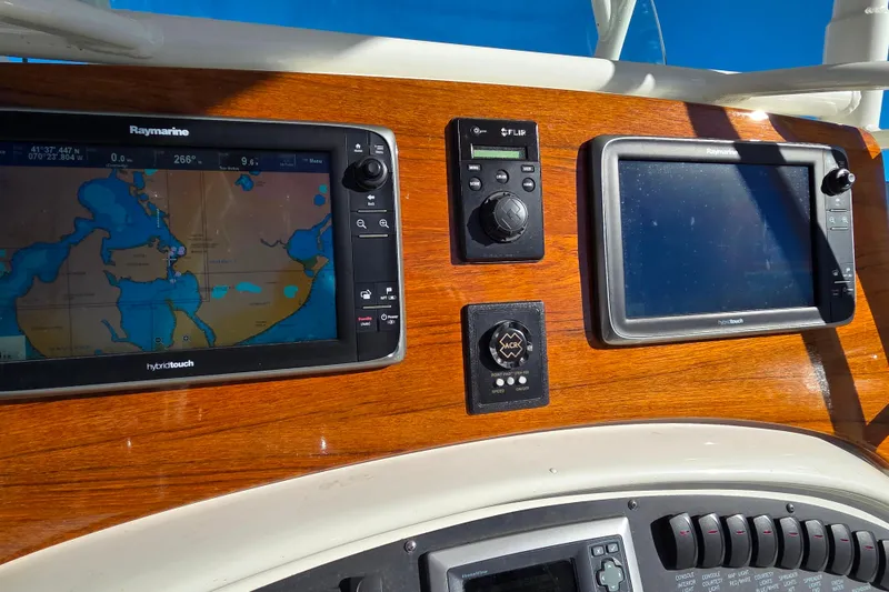 Slide: The Image of Dashboard of a 2013 Boston Whaler 320 Outrage with navigation screens and controls. - 17