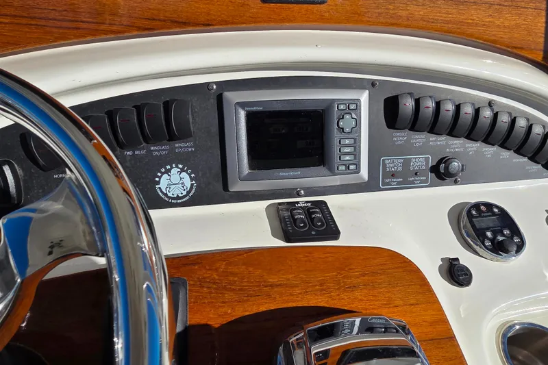 Slide: The Image of 2013 Boston Whaler 320 Outrage dashboard with controls and steering wheel. - 18