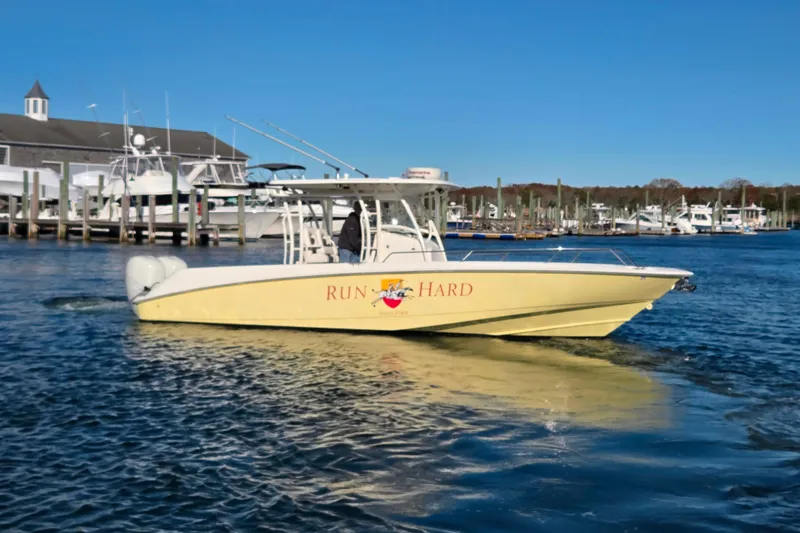 Slide: The Image of 2013 Boston Whaler 320 Outrage boat on water near marina, clear blue sky. - 2