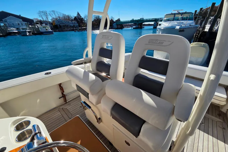 Slide: The Image of 2013 Boston Whaler 320 Outrage boat interior with comfortable seating and scenic waterfront view. - 22