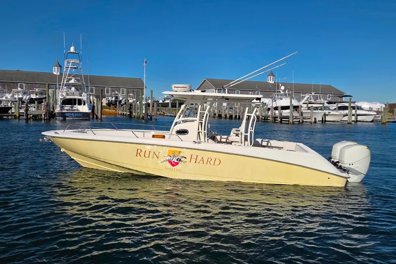 Slide: The Image of 2013 Boston Whaler 320 Outrage boat docked in a marina under clear blue skies. - 3