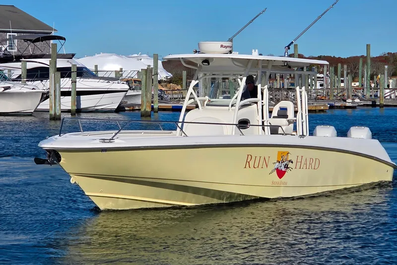 Slide: The Image of 2013 Boston Whaler 320 Outrage boat docked in marina, featuring "Run Hard" logo. - 4