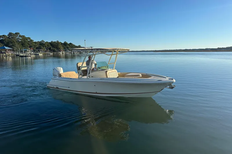 The Image of 2016 Chris-Craft Catalina 23 boat cruising on calm water under clear blue sky. - 1