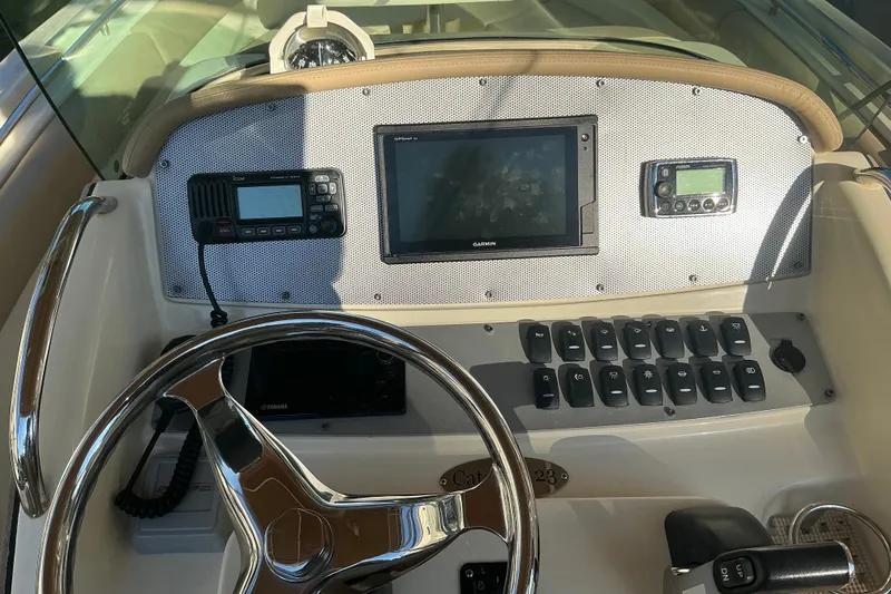 Slide: The Image of 2016 Chris-Craft Catalina 23 dashboard with steering wheel, navigation, and control panel. - 16