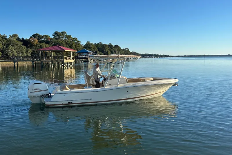 Slide: The Image of 2016 Chris-Craft Catalina 23 boat on calm water near a dock, clear blue sky. - 2