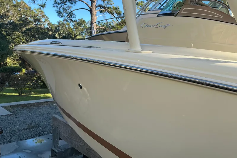 Slide: The Image of 2016 Chris-Craft Catalina 23 boat, sleek design, parked outdoors, surrounded by trees. - 27