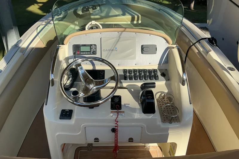 Slide: The Image of 2016 Chris-Craft Catalina 23 boat dashboard with steering wheel and Garmin navigation system. - 29