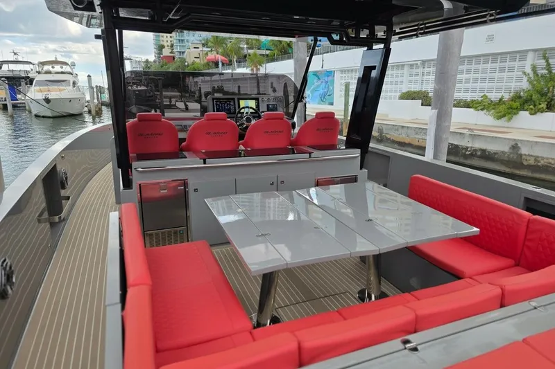 Slide: The Image of 2023 De Antonio Yachts D42 Open with red seating and sleek design at a marina. - 15