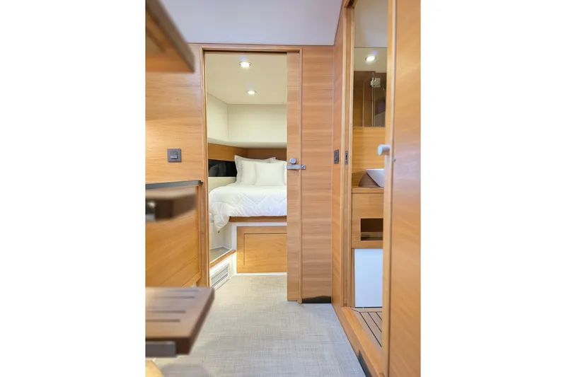 Slide: The Image of Interior of 2023 De Antonio Yachts D42 Open, featuring a cozy bedroom and modern wood finishes. - 18