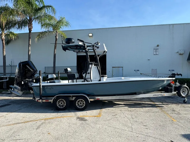The Image of 2025 Yellowfin 24 CE boat on trailer, parked outdoors near palm trees. - 0
