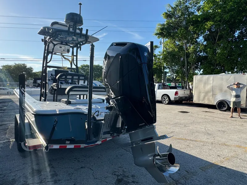 Slide: The Image of 2025 Yellowfin 24 CE boat with powerful outboard motor, parked outdoors on a sunny day. - 10