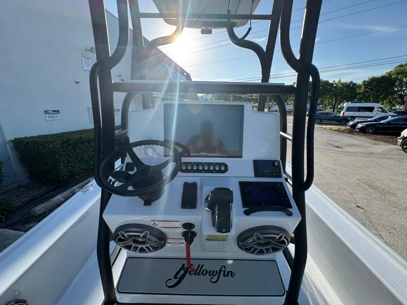Slide: The Image of 2025 Yellowfin 24 CE boat console with steering wheel and electronic controls. - 11