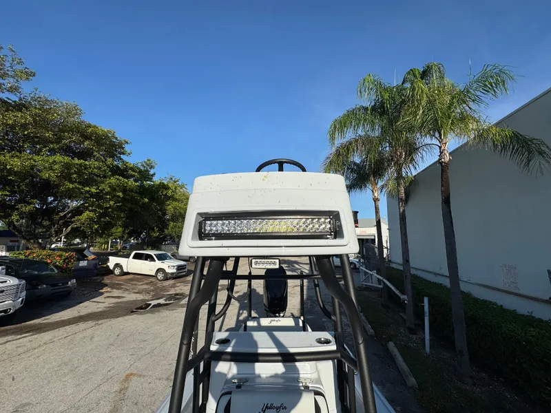 Slide: The Image of 2025 Yellowfin 24 CE boat with LED light bar, parked near palm trees. - 16