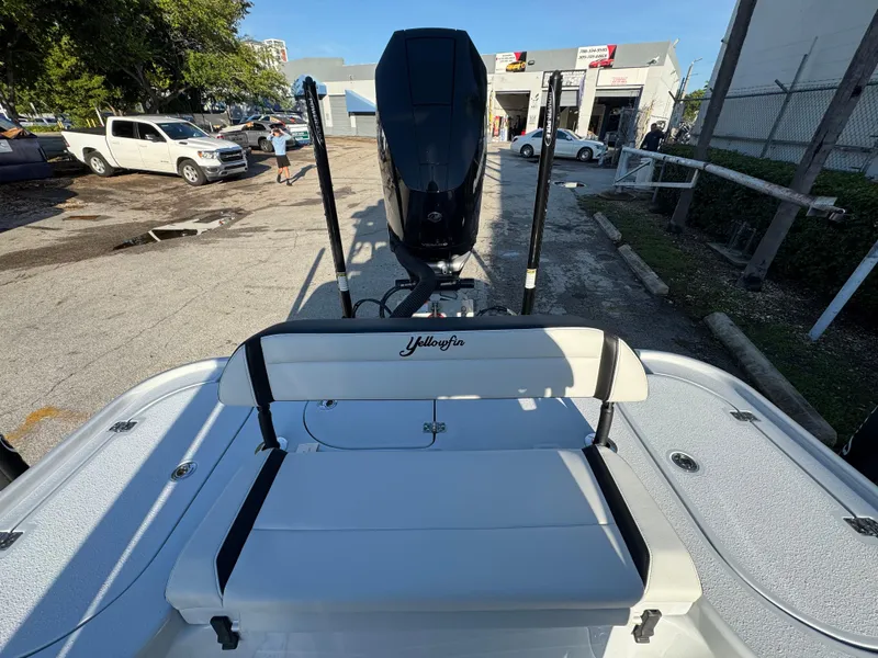 Slide: The Image of 2025 Yellowfin 24 CE boat with seating and motor, parked outdoors. - 18